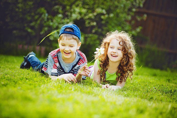 little-girl-boy-lying-on-grassgreen-How-Long-Does-it-Take-to-Grow-Grass