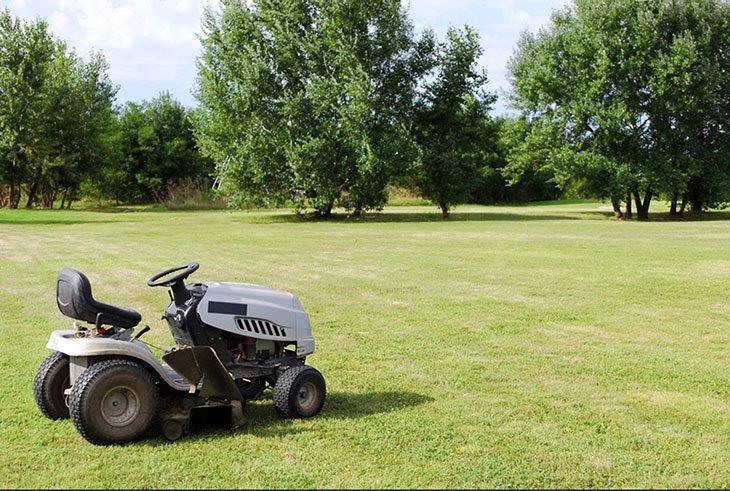 A riding lawn mower on the field
