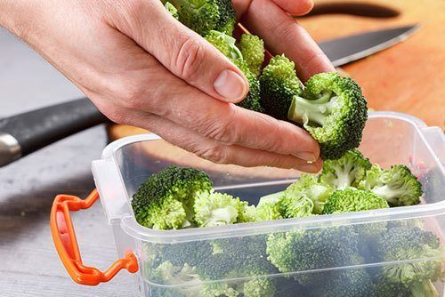 Chef-puts-broccoli-into-the-tray-for-freezing